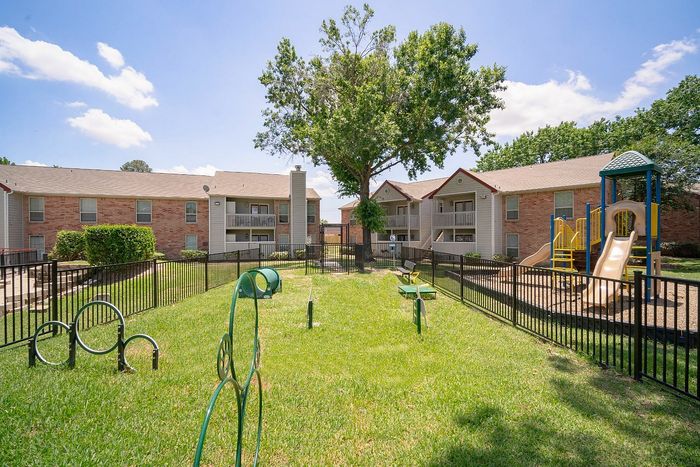 Charming apartment complex with spacious balconies, lush green lawns, and a vibrant playground for residents.