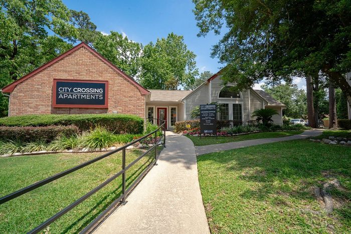 Charming entrance of City Crossing Apartments surrounded by lush greenery and inviting landscaping.