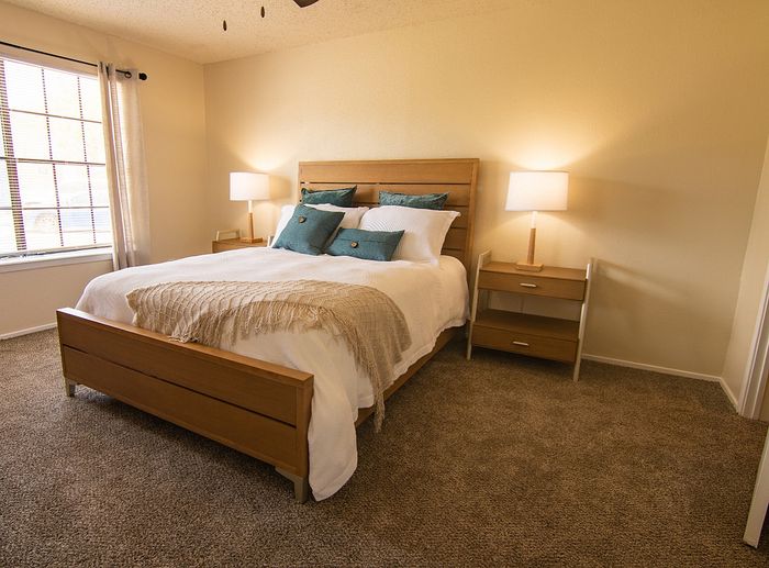 Inviting bedroom with a cozy queen-sized bed, elegant wooden furnishings, and soft natural lighting.