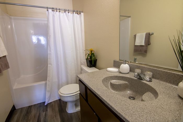 Contemporary bathroom with sleek granite countertops, elegant white fixtures, and modern decor.