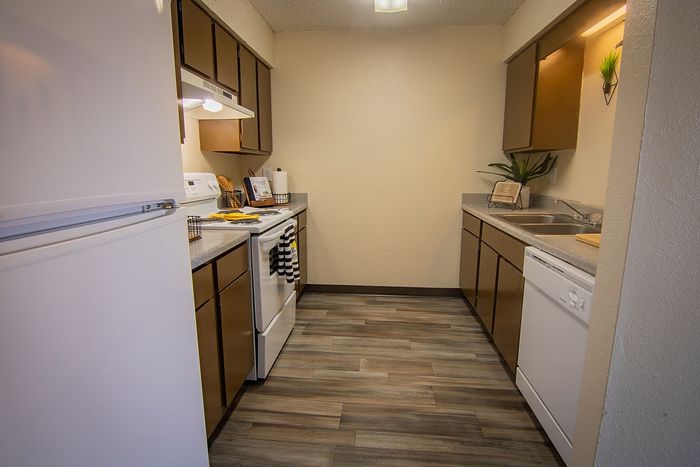 Cozy kitchen with modern appliances, sleek cabinetry, and elegant wood flooring, perfect for culinary creativity.