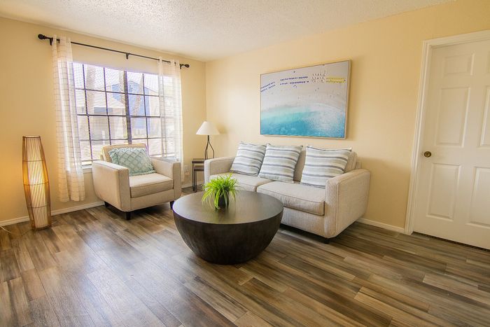 Bright and inviting living room with cozy seating, stylish decor, and beautiful wood flooring, perfect for relaxation and entertainment.
