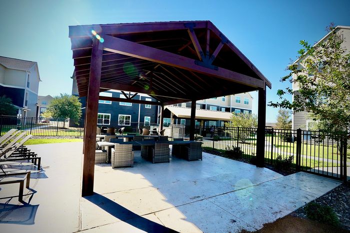 Charming outdoor patio with stylish gazebo and comfortable seating, perfect for relaxation and social gatherings, surrounded by lush greenery.