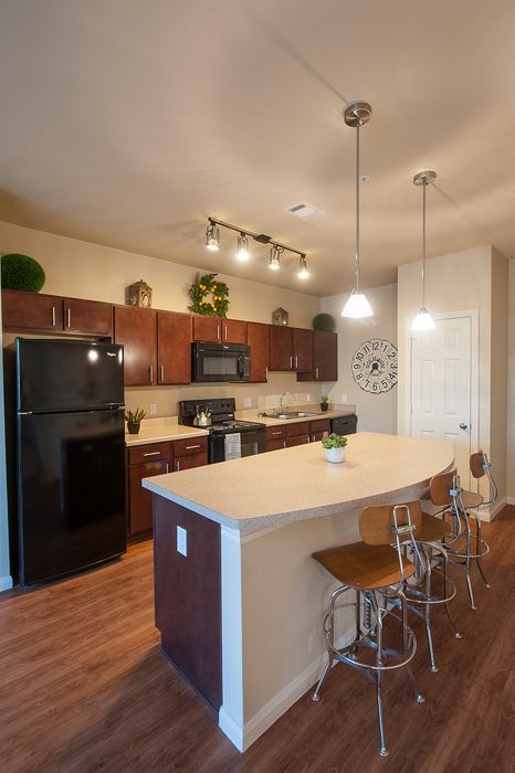 Modern kitchen with sleek cabinetry, elegant lighting, and a stylish breakfast bar with chic seating.