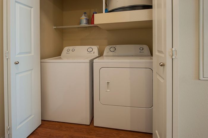 Efficient laundry setup featuring a modern washer and dryer with ample shelving in a cozy nook.