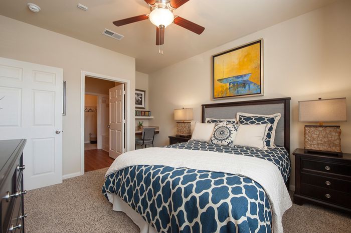 Elegant bedroom featuring stylish decor, a cozy bed with patterned linens, and ample lighting for a serene atmosphere.
