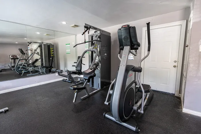 Modern home gym with state-of-the-art exercise equipment, including a sleek elliptical and versatile multi-gym, perfect for a comprehensive workout.