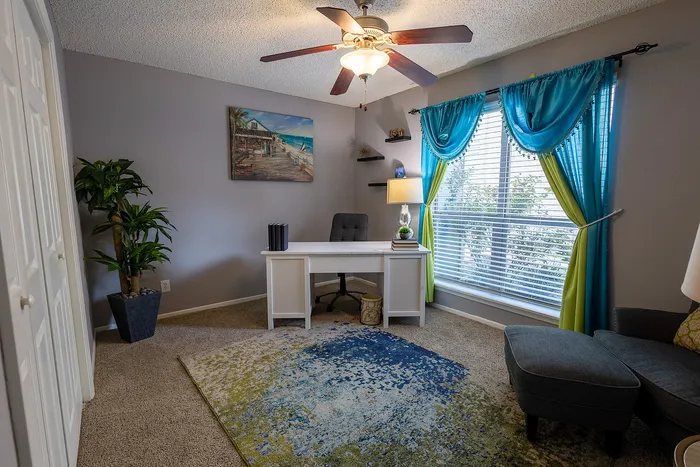 Inviting home office with a bright window, elegant desk, and vibrant decor for a productive atmosphere.