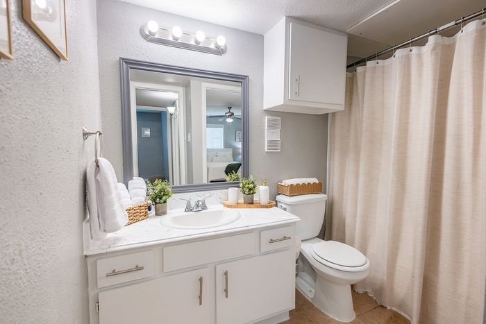 Bathroom vanity and tub at Huntington Oaks Apartments in Alvin, TX.