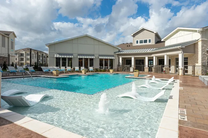 Resort-style swimming pool with lounge seating and water features at Lakeview at Westpark apartments in Richmond, TX