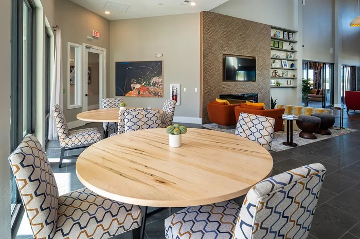 Modern clubhouse lounge with seating, wall-mounted TV, and large windows at Lakeview at Westpark apartments in Richmond, TX