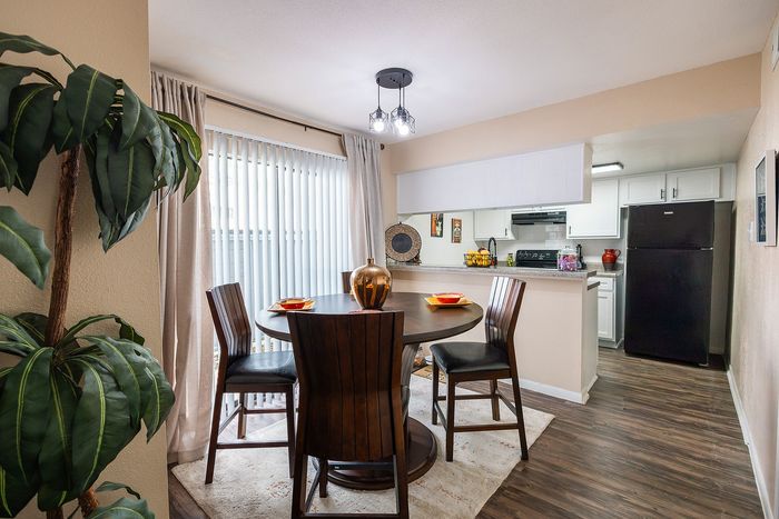 Dining area with breakfast bar and updated flooring at Waterchase Apartments in Humble, TX