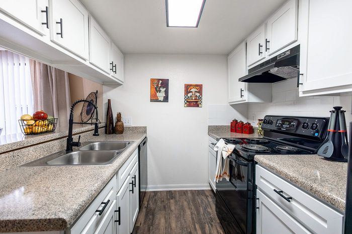 Full kitchen layout with updated cabinets, countertops, and appliances at Waterchase Apartments