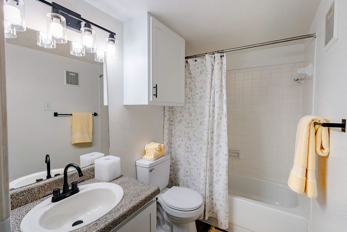 Bathroom with tub and shower combination and updated vanity at Waterchase Apartments
