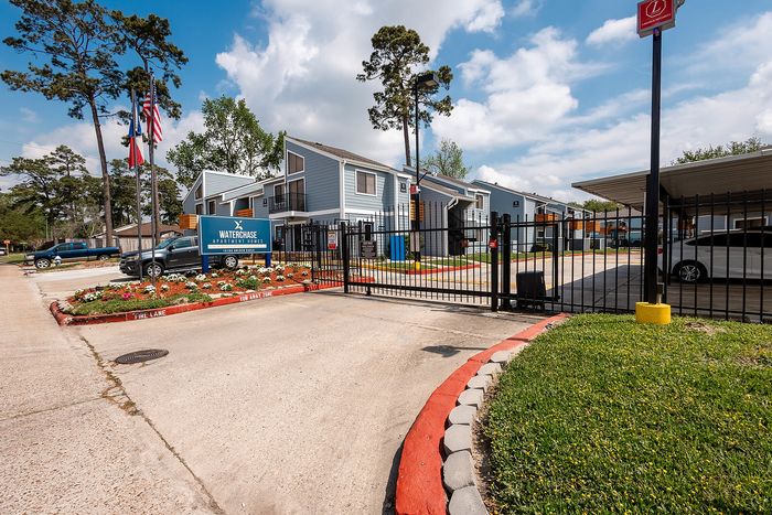 Gated entrance and community signage at Waterchase Apartments in Humble, TX