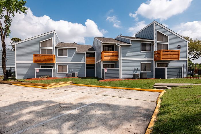 Updated apartment buildings with blue siding and private balconies at Waterchase Apartments