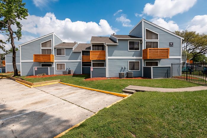 Apartment exterior with wood-style balcony accents at Waterchase Apartments in Humble, TX