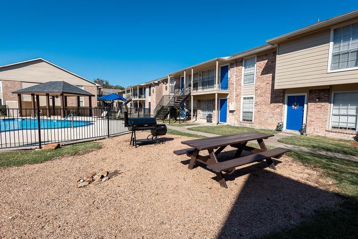 Swimming pool and courtyard seating area at Steeplechase Apartments in Alvin TX