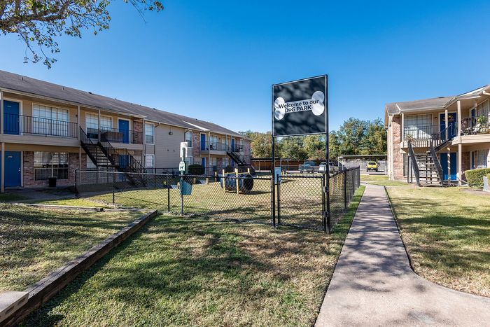 Dog park entrance with fenced pet area at Steeplechase Apartments in Alvin TX