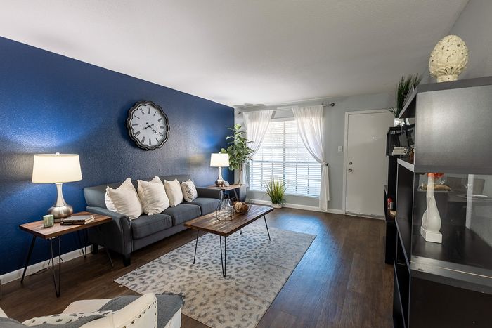Dining area with modern light fixture, round table seating for four, and decorative mirror