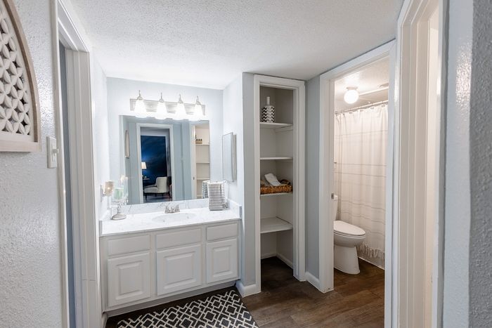 Bathroom vanity with updated countertop, modern fixtures, and mirror lighting