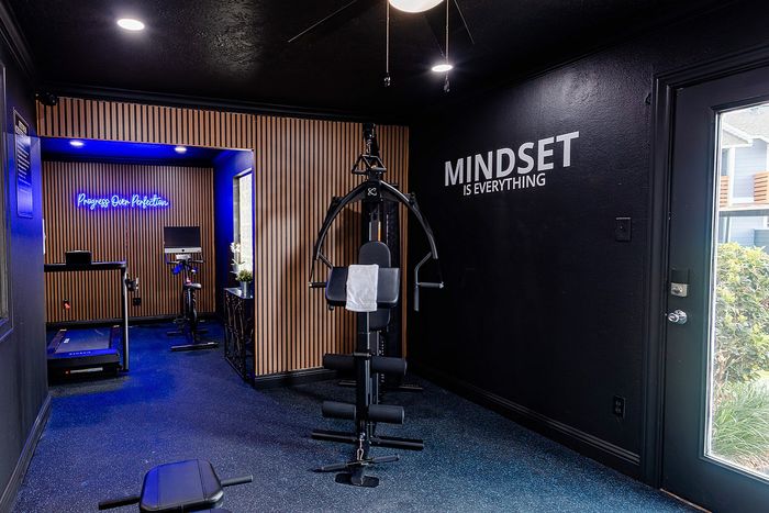 Modern home gym with sleek equipment, motivational wall art, and vibrant lighting for an invigorating workout experience.