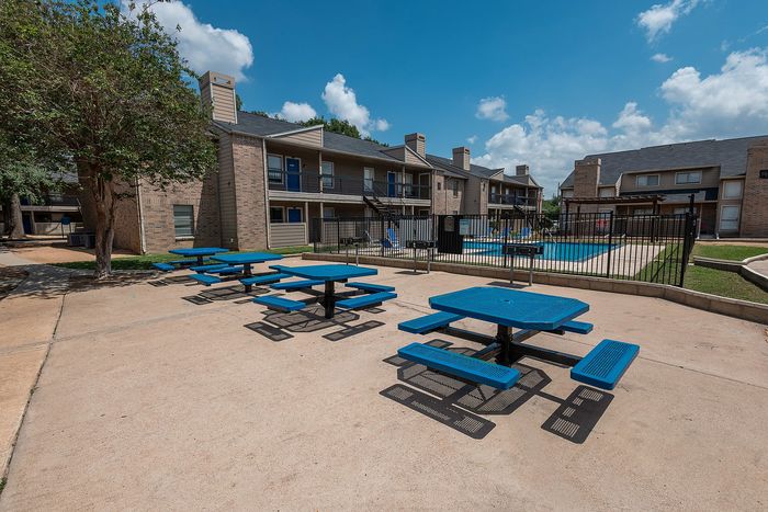 Pool lounge area with shaded seating at Green Meadows Apartments in Houston, TX