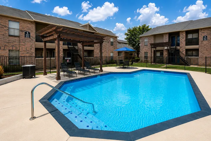 Resort-style swimming pool with pergola seating at Green Meadows Apartments in Houston TX