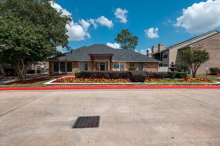 Landscaped clubhouse and leasing office exterior at Green Meadows Apartments in Houston TX