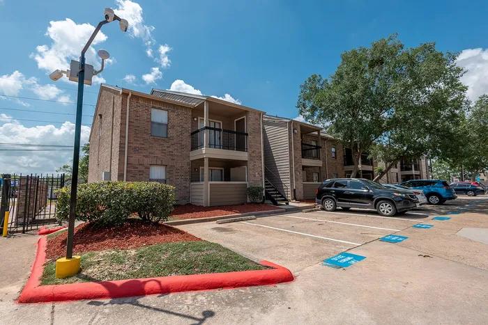 Apartment building with resident parking at Green Meadows Apartments in Houston TX