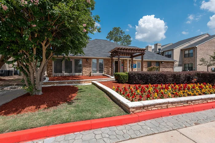 Leasing office exterior with landscaped entrance at Green Meadows Apartments in Houston TX