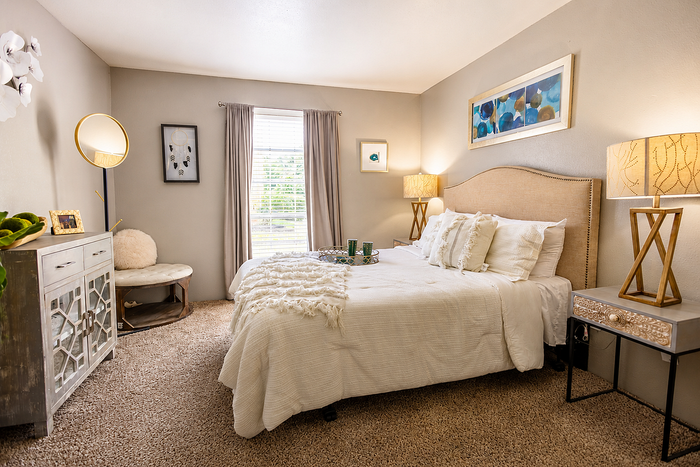 Comfortable bedroom interior at Newport Oaks Apartments in Alvin, TX with soft natural lighting and neutral finishes.