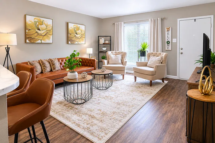 Bright living room interior at Newport Oaks Apartments in Alvin, TX featuring wood-style flooring, modern furnishings, and natural light.