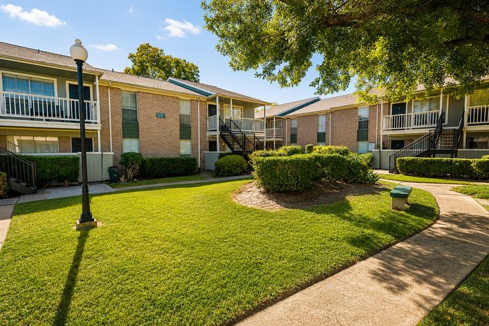 Landscaped courtyard with mature trees at Huntington Oaks Apartments