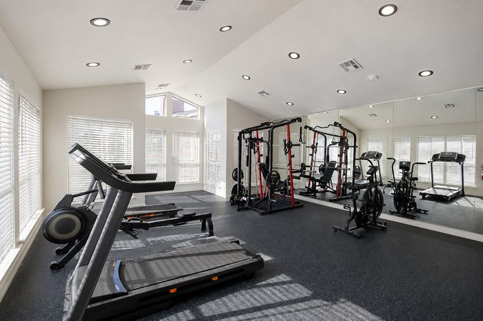 Fitness center at Deerbrook Gardens in Humble, TX featuring strength training equipment, cardio machines and an air bike.