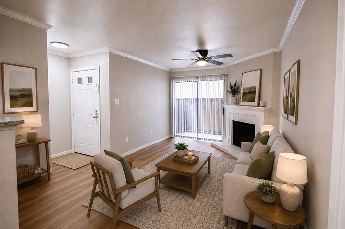 Alternate view of the Deerbrook Gardens living room in Humble, TX featuring a fireplace, comfortable seating and open-concept layout.