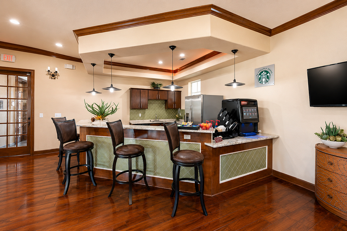 Elegant kitchen area with modern bar seating, stylish pendant lighting, and sleek appliances, perfect for entertaining.