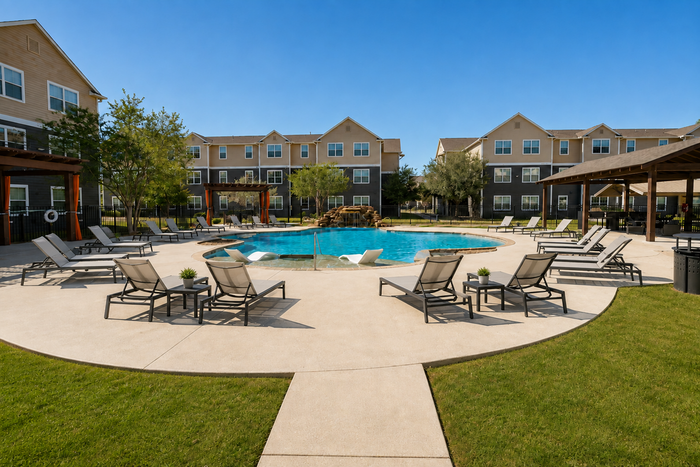 Pool and surrounding lounge area at Oak Tree Apartments in Kingsville, TX, featuring a resort-style setting for residents.
