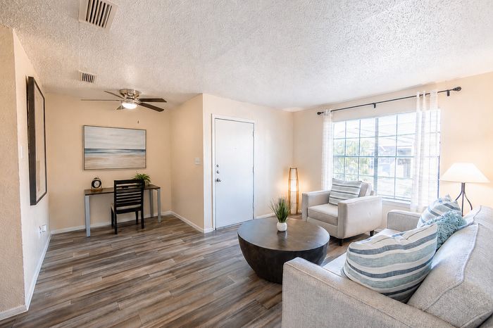 Furnished living room at Apple Creek featuring comfortable seating, wood-style flooring and a dedicated work-from-home area.