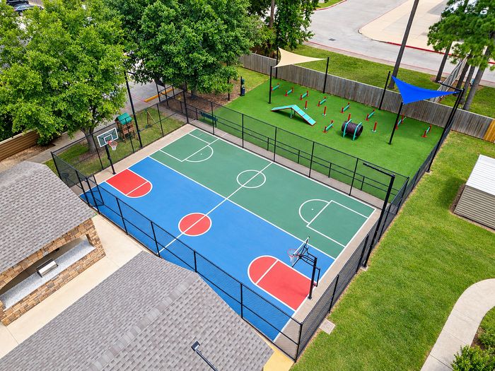 Aerial view of the fenced basketball court and adjacent pet agility area at Parkside Apartments.
