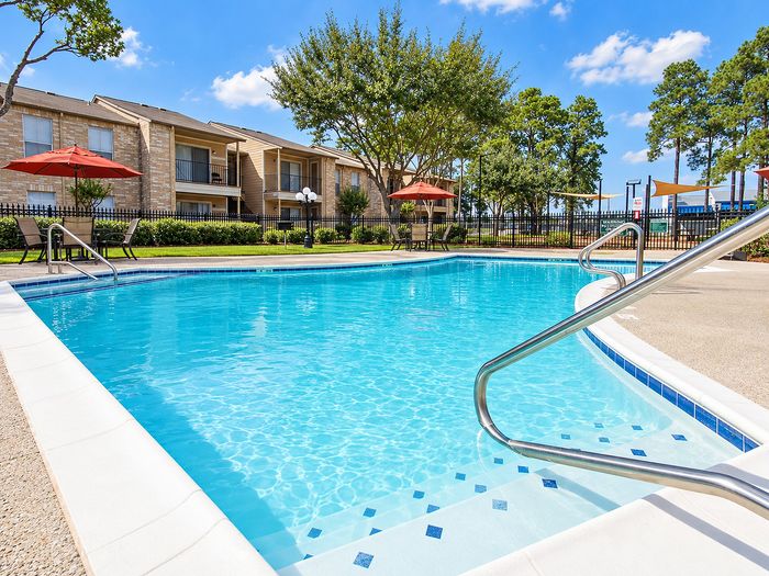 Close view of the Parkside Apartments swimming pool with entry steps, handrails and surrounding patio.