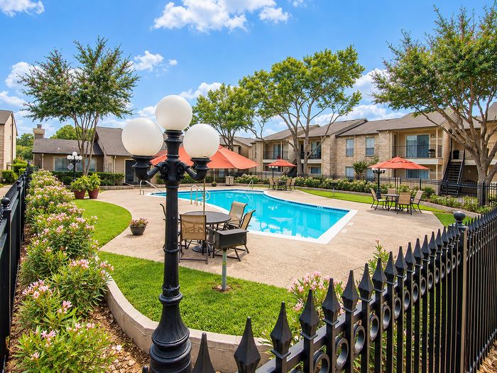 Parkside Apartments swimming pool with clean patio areas, maintained landscaping and surrounding apartment homes.