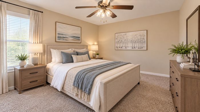 Spacious staged bedroom with neutral bedding, wood furniture, carpet and natural light at Parkside Apartments.