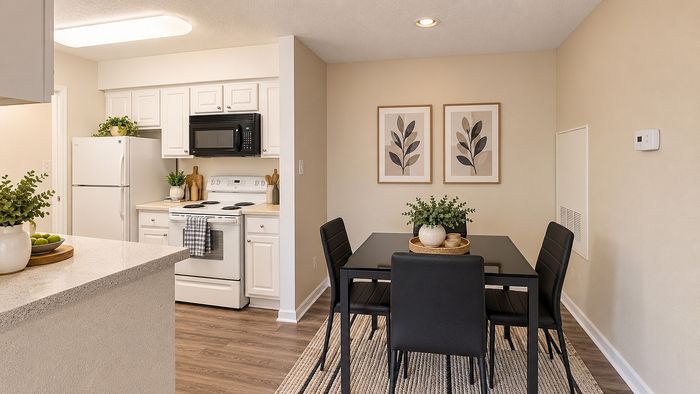Dining area with four-person table beside the white-cabinet kitchen at Parkside Apartments.