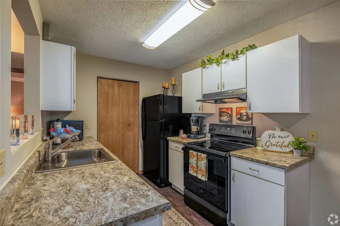 Charming kitchen with modern appliances, elegant countertops, and warm lighting for a cozy atmosphere.