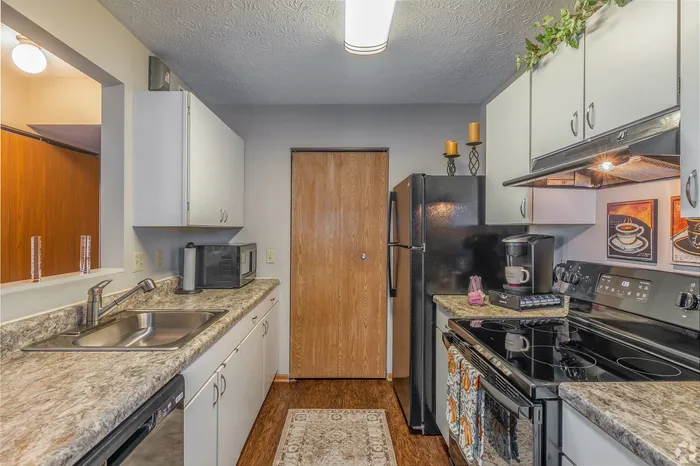 Modern kitchen featuring sleek appliances, elegant marble countertops, and ample cabinet space, perfect for culinary enthusiasts.