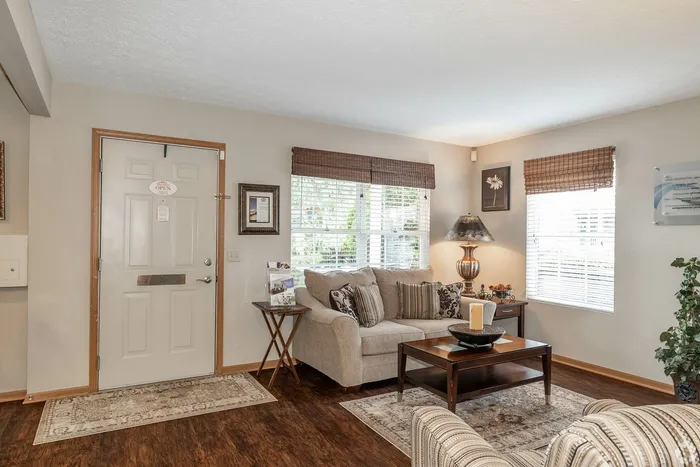 Inviting living room with cozy beige sofa, stylish decor, and large windows offering abundant natural light.