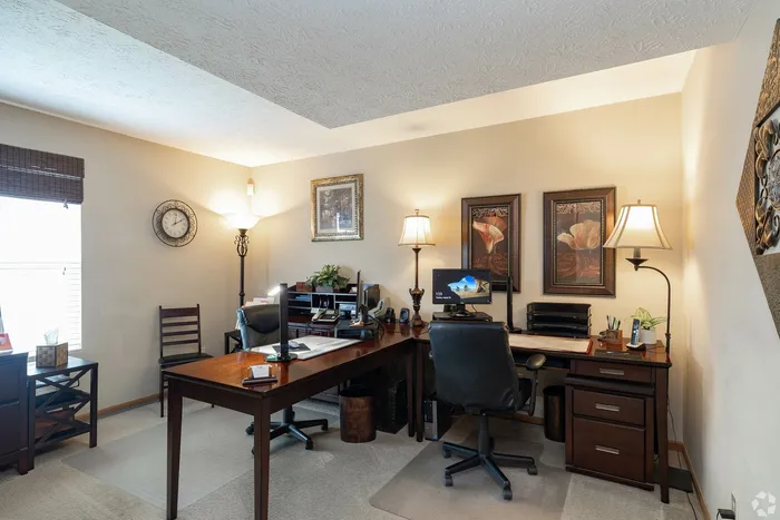 Charming home office with elegant wooden desks, modern decor, and warm lighting, perfect for productivity and comfort.