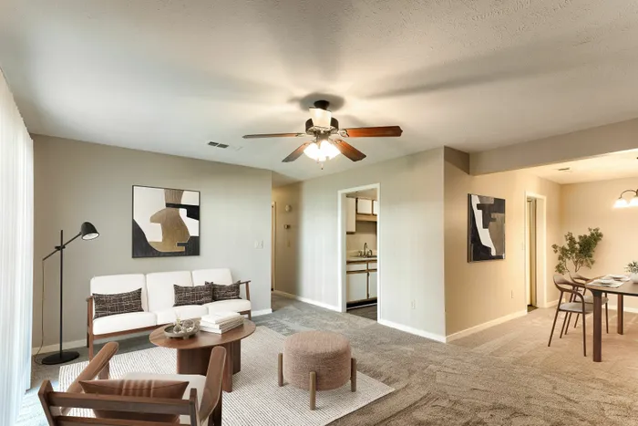 Inviting living room with modern decor, cozy seating, and elegant dining area, complemented by warm lighting and neutral tones.