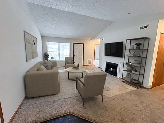Cozy living room with plush seating, modern decor, and natural light pouring through a large window.